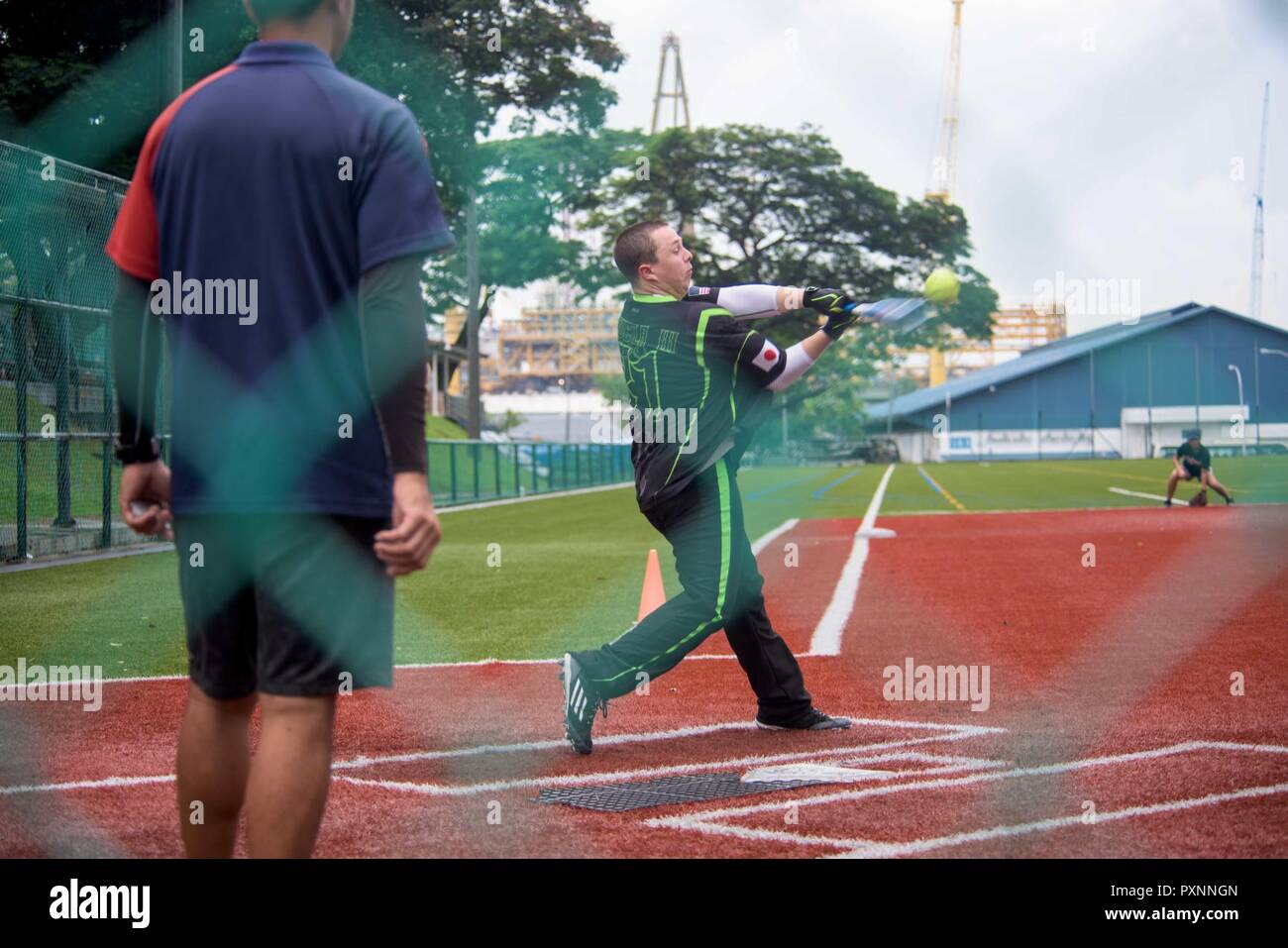 Singapur (18. Juni 2017) Mass Communication Specialist 3. Klasse Charles Scudella, von Phoenix, schlägt einen Softball an eine Moral, Wohlfahrt und Erholung (MWR) Softball Spiel gegen eine lokale Mannschaft während der Marine vorwärts gesponserte bereitgestellten Flugzeugträger USS Ronald Reagan (CVN 76), port Besuch in Singapur. Matrosen zu Ronald Reagan zugeordnet nahm an drei MWR Sport Spiele, darunter Fußball, Baseball und Basketball im Anschluss Besuch in Singapur gefördert. Ronald Reagan, das Flaggschiff der Carrier Strike Group 5, bietet eine Bekämpfung bereit, Kraft, schützt und verteidigt die kollektive Mar Stockfoto