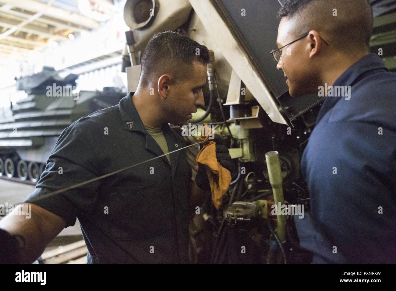 Bekämpfung der Cargo Marines mit Combat Logistik Bataillon 31 Kette ein Traktor zum Deck der USS Ashland (LSD 48) im Pazifischen Ozean, 10. Juni 2017. Wie die Logistik Combat Element der 31 Marine Expeditionary Unit, CLB-31 unterstützt eine Vielzahl von Kampf- und nicht-Einsätze, einschließlich der humanitären Hilfe und Katastrophenhilfe. Die 31. MEU Partner mit Amphibischen Squadron 11 der Marine Bonhomme Richard Expeditionary Strike Group zu bilden. Die 31. MEU und PHIBRON 11 Mähdrescher ein zusammenhängendes Blau-grün Team, das in der Lage ist, eine Vielzahl von Missionen im gesamten Indio-Asia-Pa zur Verfügung zu stellen Stockfoto