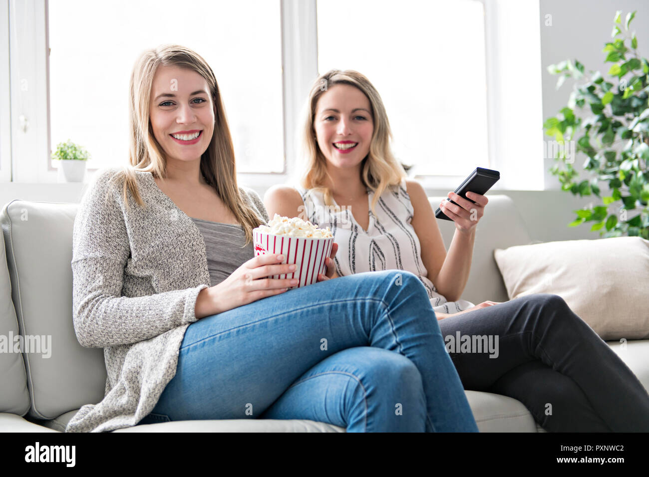 Zwei Freunde Film zu Hause ansehen Mit Popcorn Stockfoto