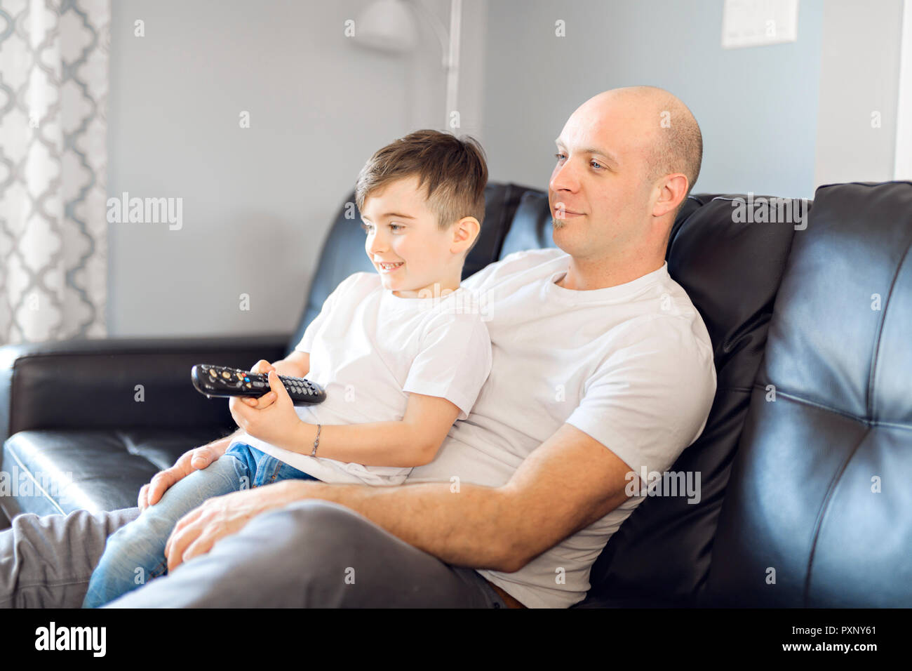 Mann und Junge tv mit Fernbedienung Stockfoto