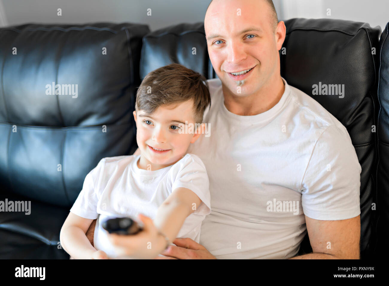 Mann und Junge tv mit Fernbedienung Stockfoto