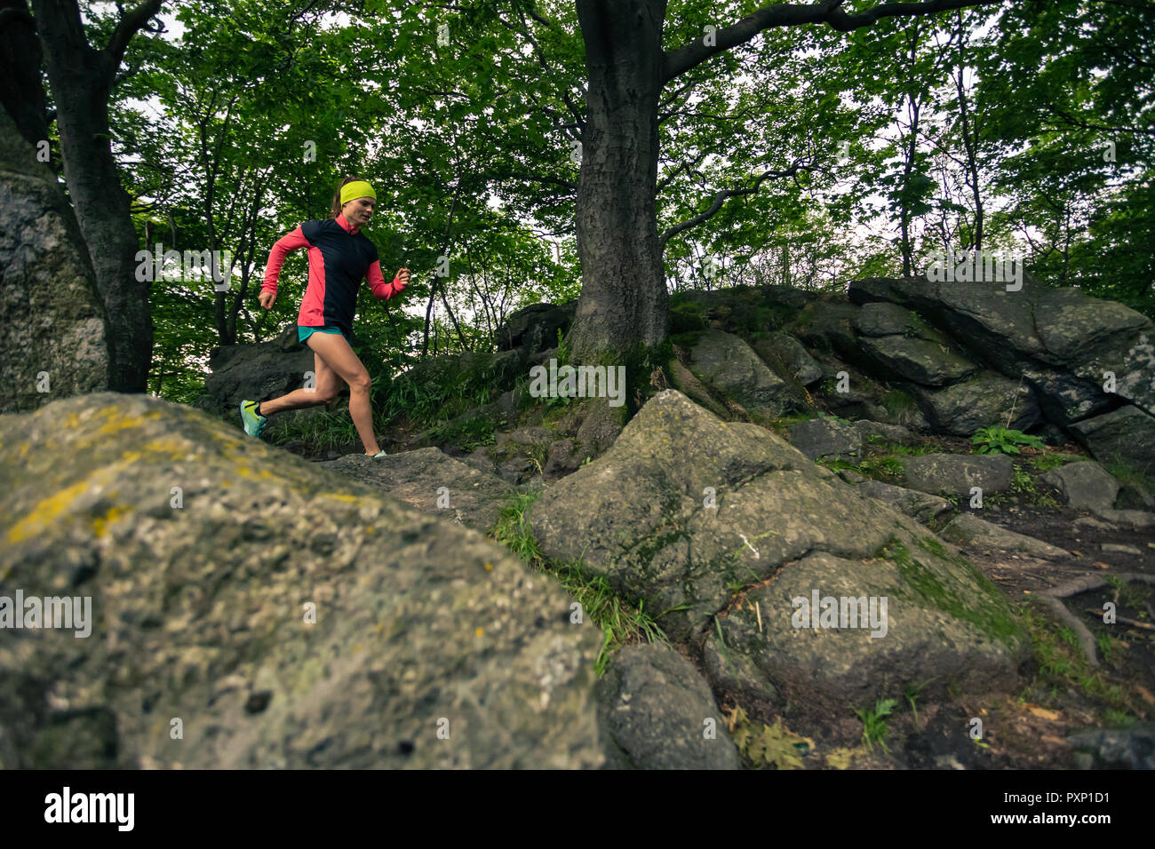 Trail Running Girl im grünen Wald. Ausdauer sport training. Weibliche Trail Runner querfeldein laufen. Sport und Fitness Concept draussen in der Natur. Stockfoto
