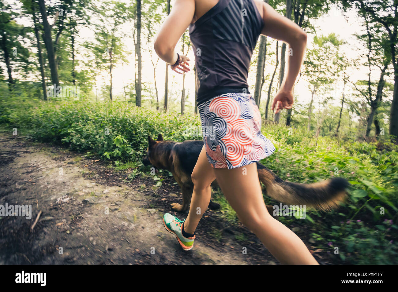 Trail Running athletische Frau im grünen Wald, Sport Inspiration und Motivation. Weibliche Trail Runner querfeldein laufen. Fitness Concept draußen Ich Stockfoto