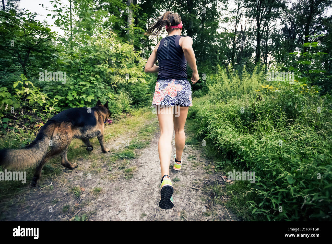 Trail Running athletische Frau im grünen Wald, Sport Inspiration und Motivation. Weibliche Trail Runner querfeldein laufen. Fitness Concept draußen Ich Stockfoto
