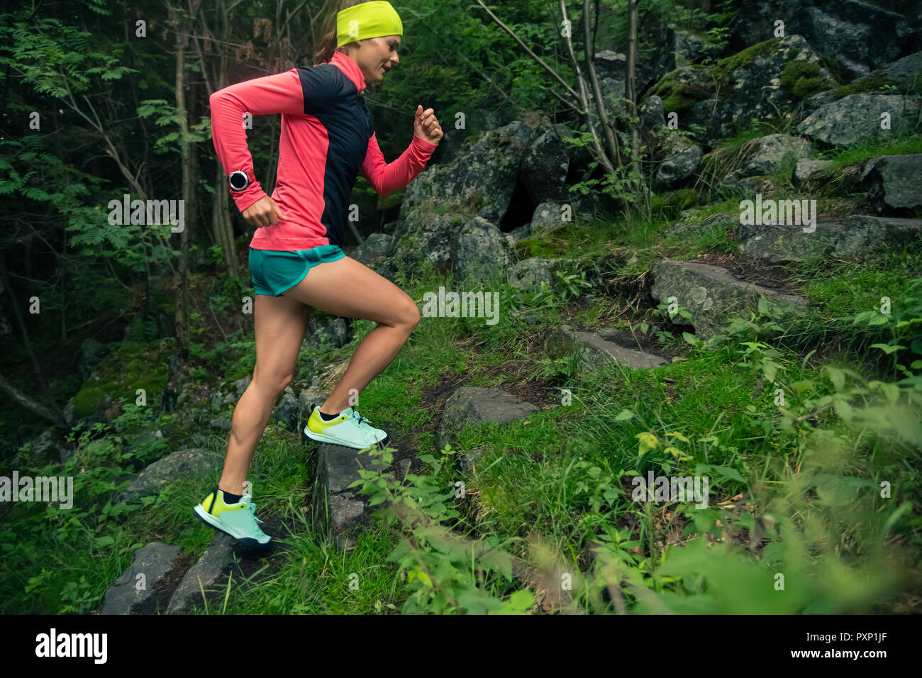 Trail Running Girl auf Steinen Schritte im grünen Wald. Ausdauer sport training. Weibliche Trail Runner querfeldein laufen. Sport und Fitness Konzept heraus Stockfoto