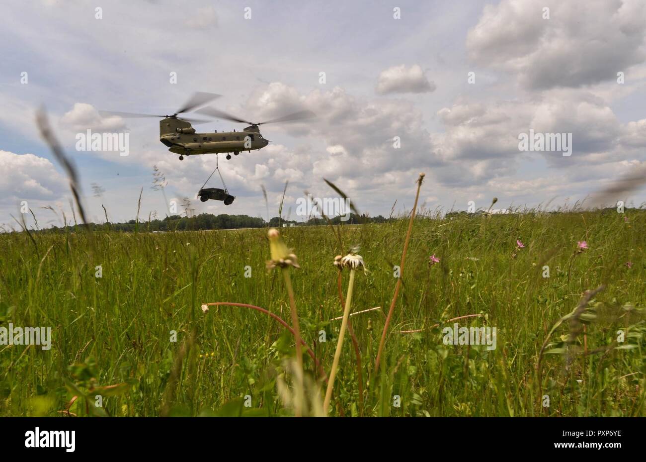 Ein U.S. Army CH-47 Chinook Hubschrauber trägt eine High Mobility Multipurpose Radfahrzeug für Sling laden die US Air Force 435th Kontingenz Reaktion der Gruppe während der Übung Sabre Strike17 am Lielvarde Air Base, Lettland, 10. Juni 2017. Die 435Th CRG Flieger arbeitete neben der US-Armee und NATO-Mitglieder während der gesamten Übung. Sabre Streik 17 weiterhin teilnehmenden Kapazität Nationen ein breites Spektrum an militärischen Operationen zu erhoehen. Stockfoto