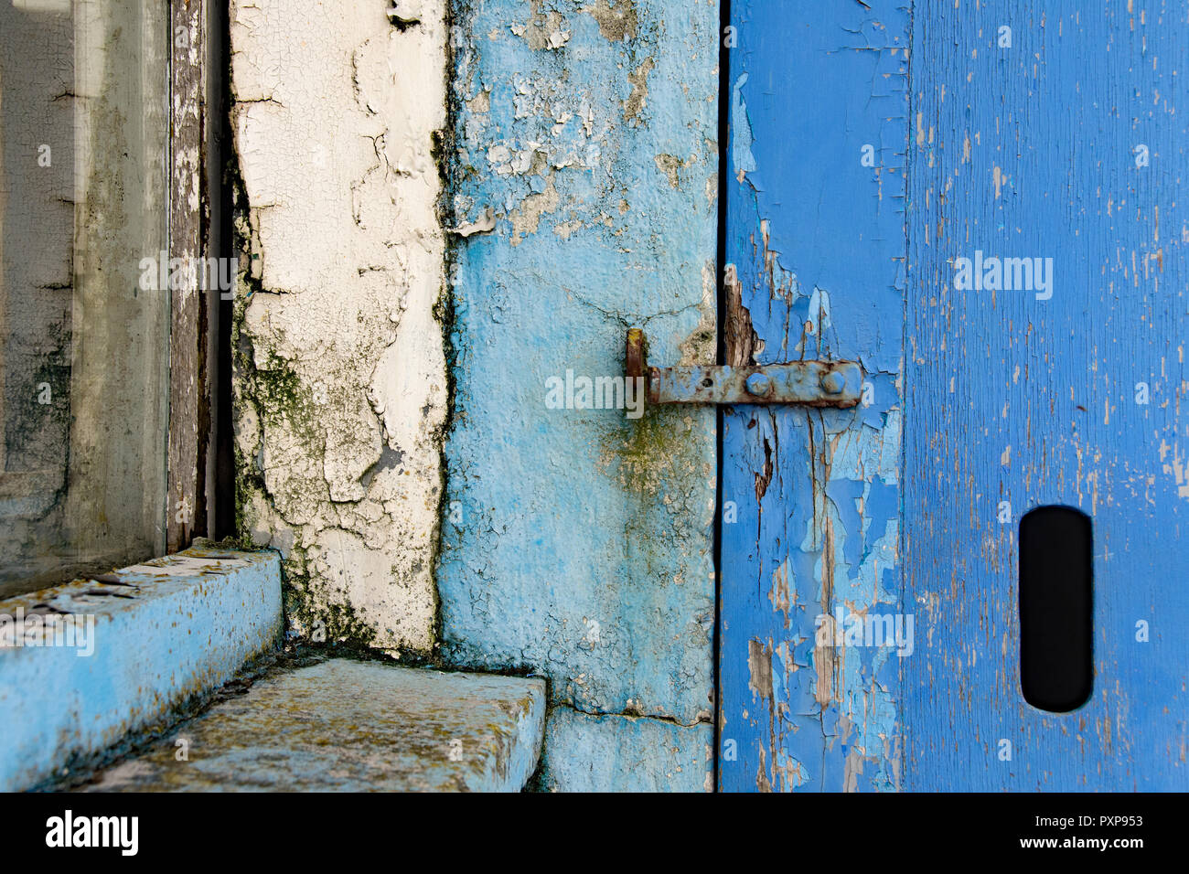 Alte Farbe auf ein Fenster und eine Tür, die in Blau und Weiß Stockfoto