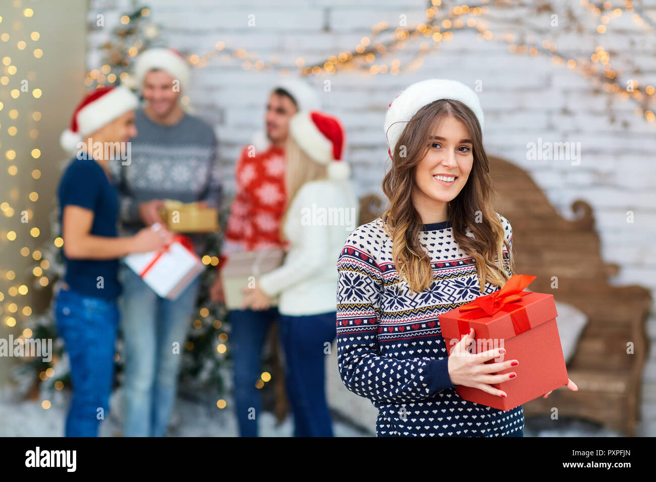 Eine Gruppe von Freunden mit Geschenken an einer Weihnachtsfeier Stockfoto