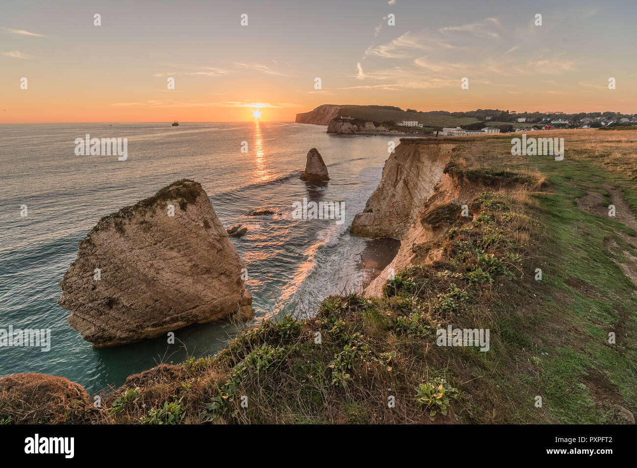 Süßwasser Sonnenuntergang. Ein herbstlicher Sonnenuntergang mit einem Sun Leiter zwischen den Hirsch und Meerjungfrau Rocksat Süßwasser, Isle of Wight Stockfoto