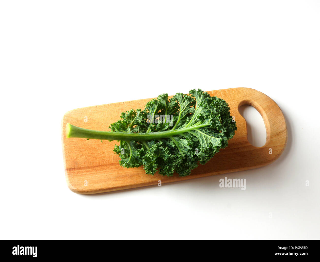 Blatt von Kale liegt auf einer hölzernen Schneidebrett. Blau geringelt Vates Kale auf weißem Hintergrund Stockfoto
