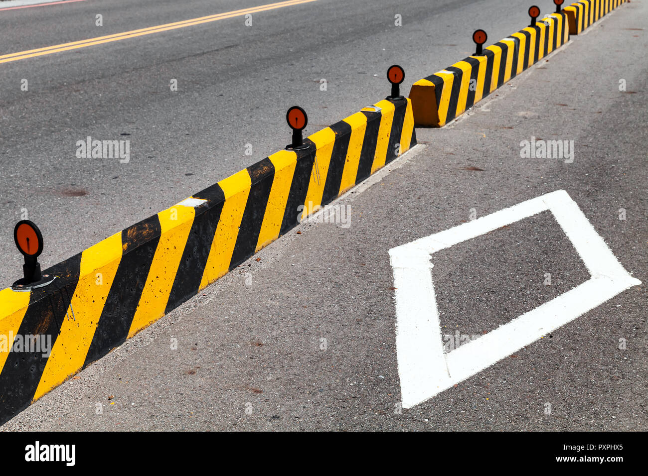 Betonsteine mit gestreiften Vorsicht Muster, Straße Zaun Bau Stockfoto