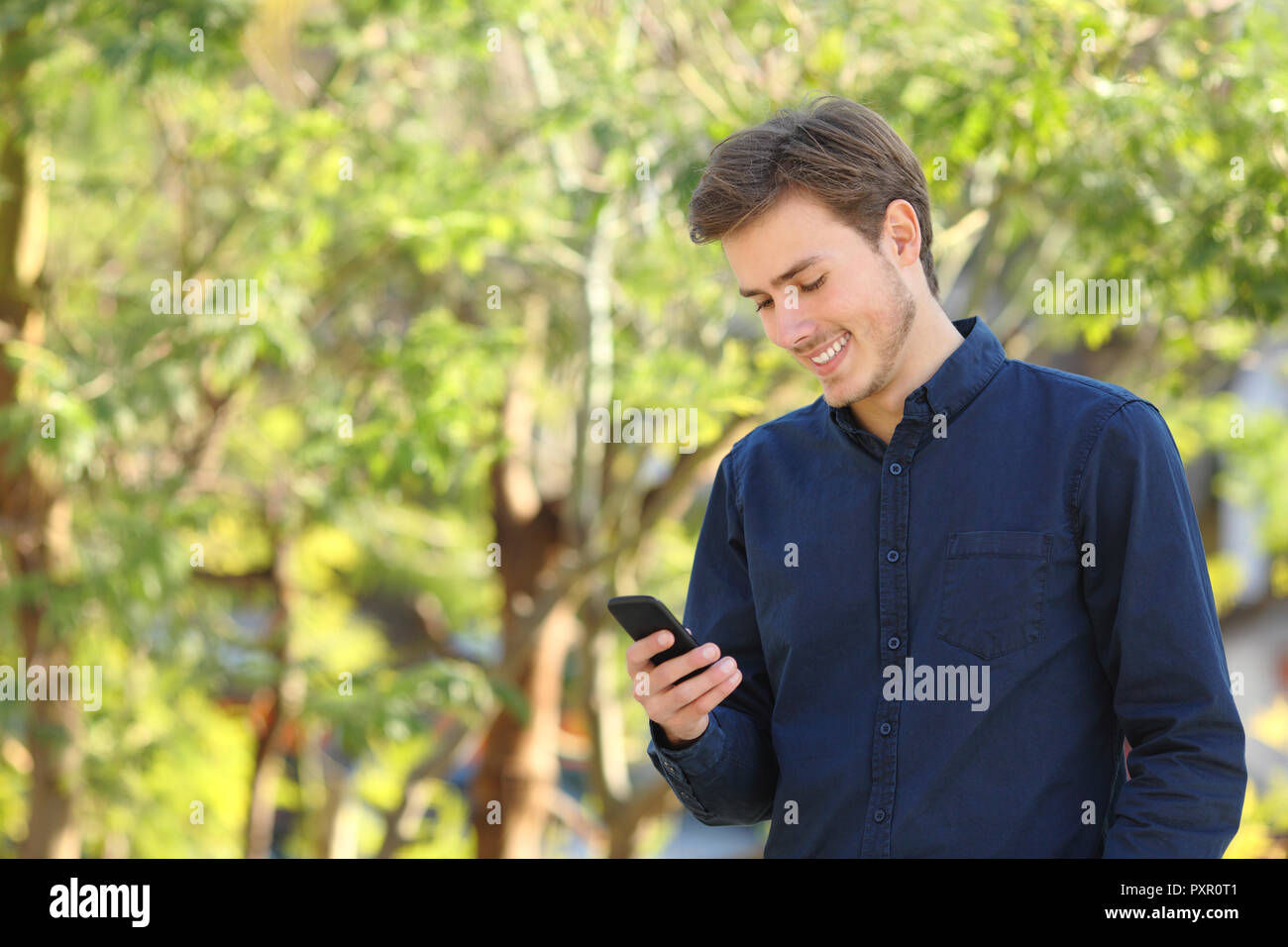 Glückliche Menschen Kontrolle smart phone Inhalt wandern in einem Park Stockfoto