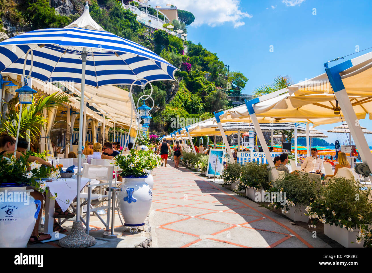 Restaurant Promenade Strand von Positano, Italien, farbenfrohes Bild perfekt Postkarte, Top Destinationen, Travel Concept Best Life, streifen Sonnenschirm, blau Stockfoto