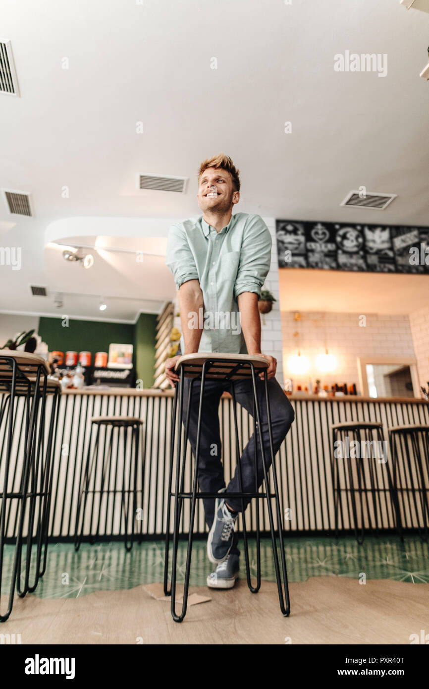 Junger Mann bei der Arbeit in seinem Start-up-cafe, schauen zuversichtlich Stockfoto