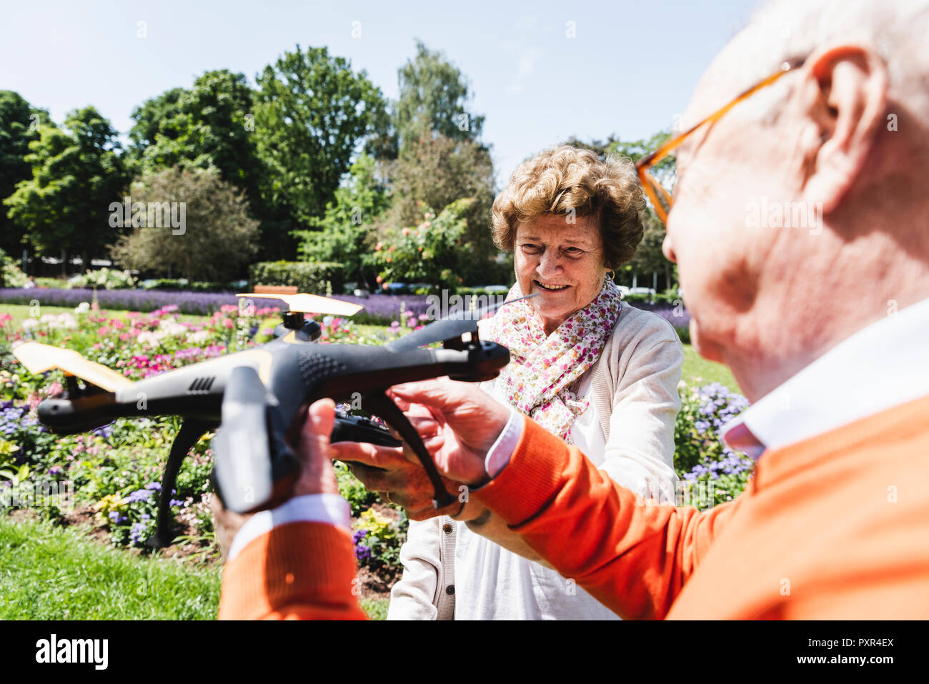 Senior Paar spielen mit einer Drohne in Park Stockfoto