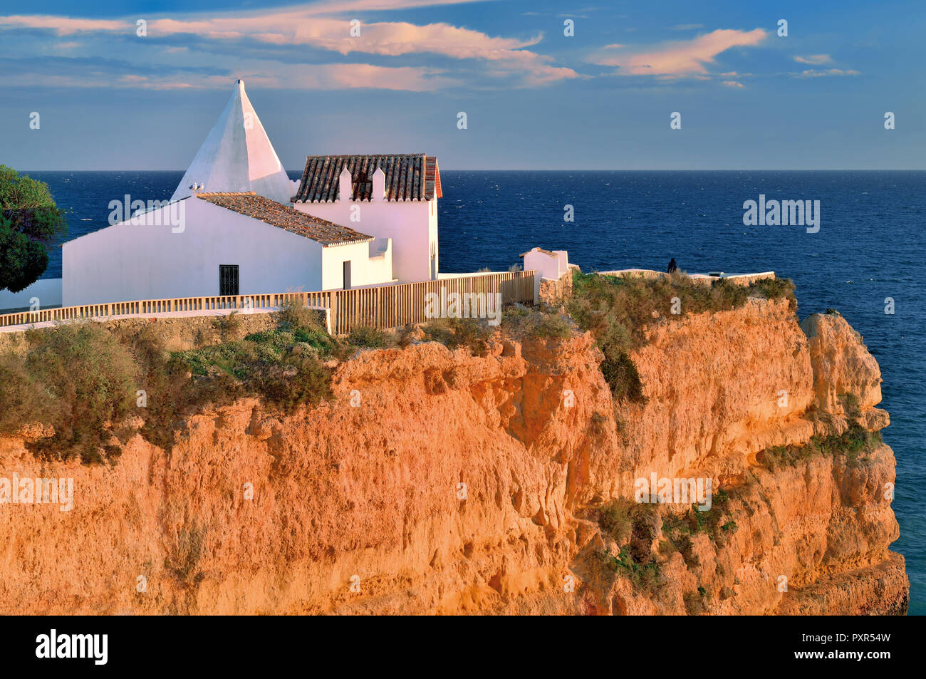 Weiß getünchten Kapelle auf einem Felsen durch blaue Meer umgeben Stockfoto