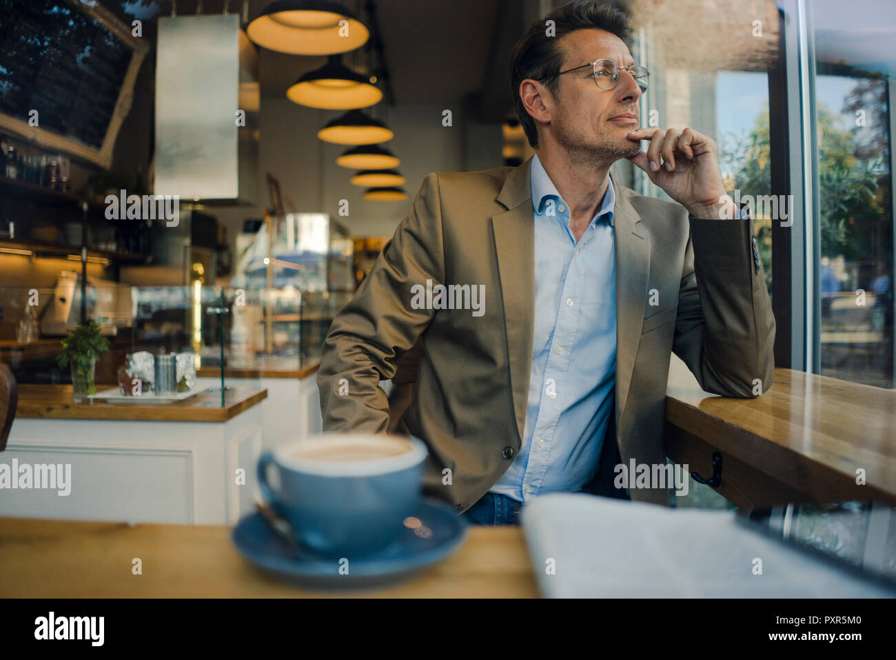 Reifen Geschäftsmann im Café sitzen, lächeln Stockfoto