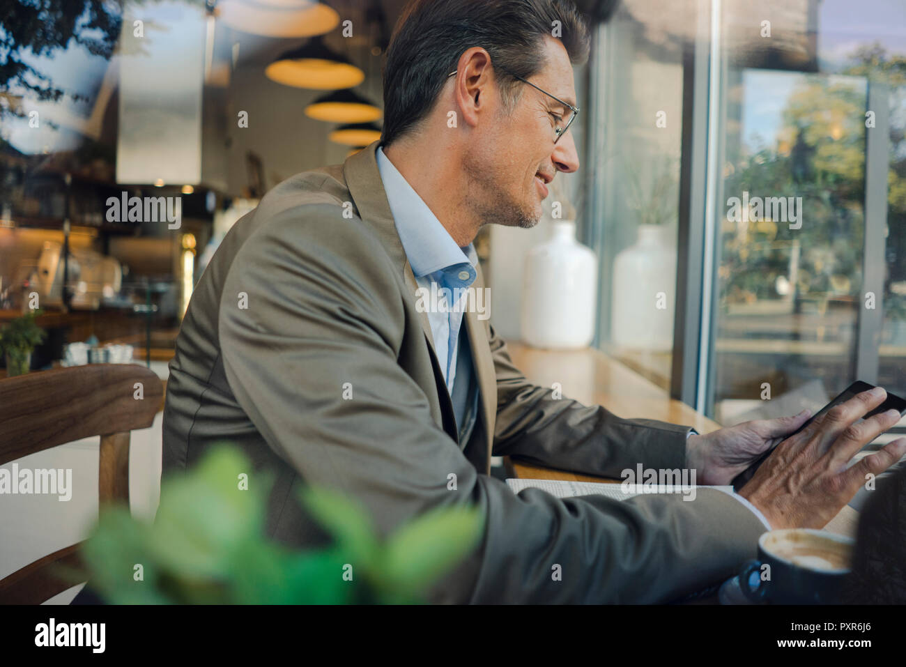 Reifen Geschäftsmann im Café sitzen, mit digitalen Tablet Stockfoto