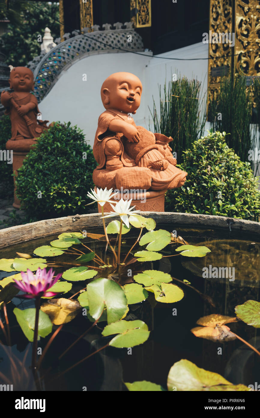 Thailand, Chiang Mai, Buddhastatuen und Teich von Seerosen in Wat Inthakhin Sadue Muang Tempel Stockfoto