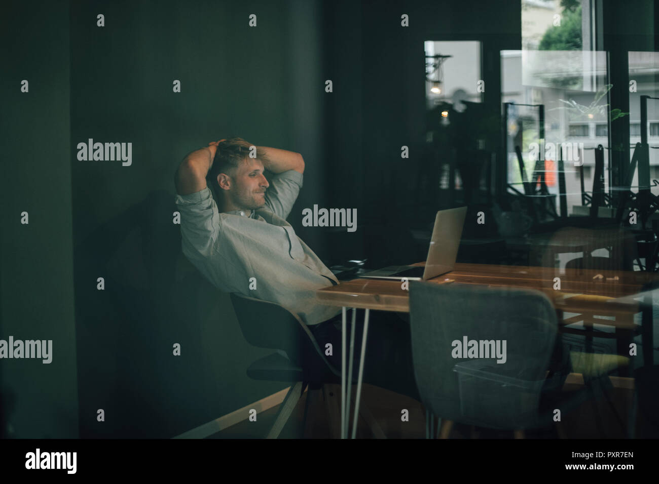 Mann sitzt im Büro, spät in seinem Start-up-Unternehmen arbeiten Stockfoto