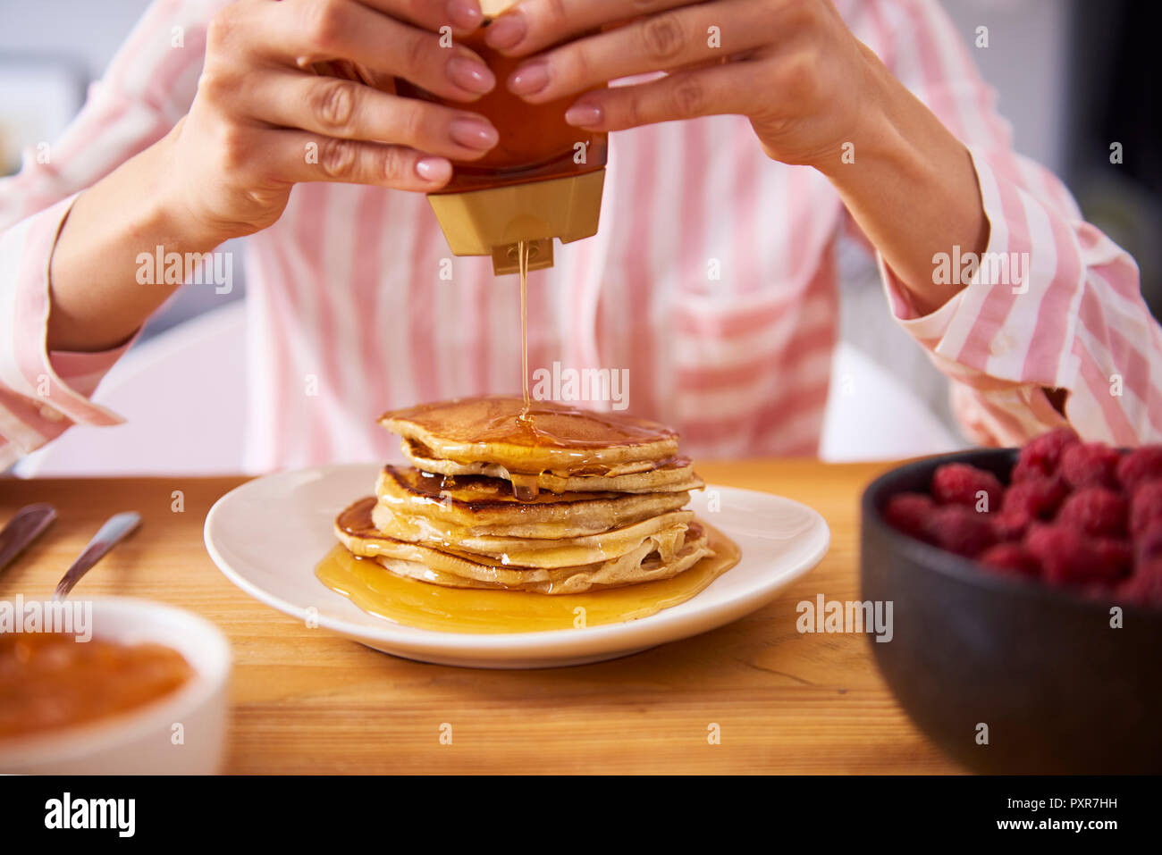 Junge Frau mit süßen Pfannkuchen zum Frühstück, in der Nähe Stockfoto