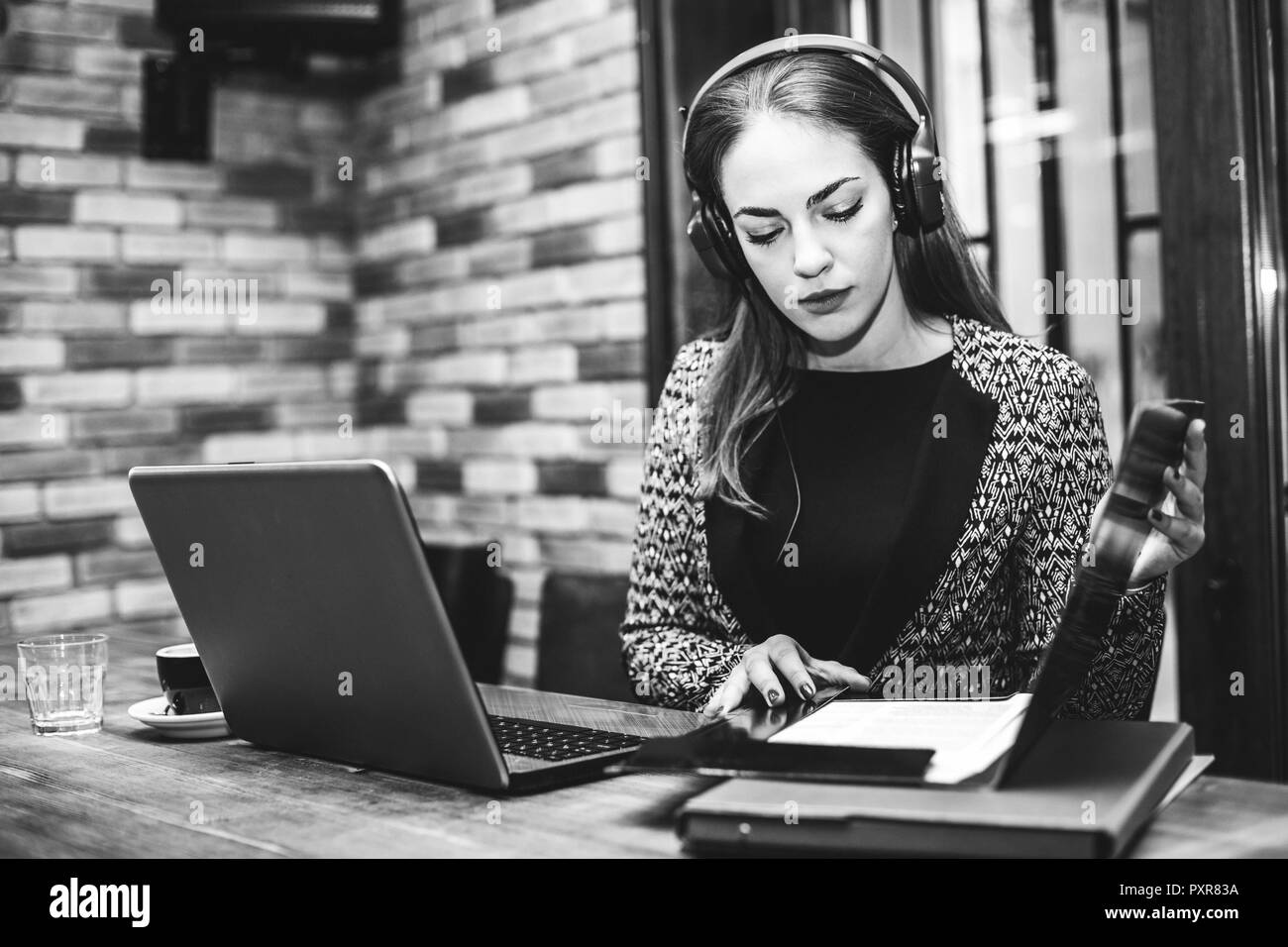 Schöne Freiberufler Frauen sprechen in einer Videokonferenz auf Linie mit einem Headset und Laptop in einer Office Desktop oder Cafe. Business woman holding docum Stockfoto