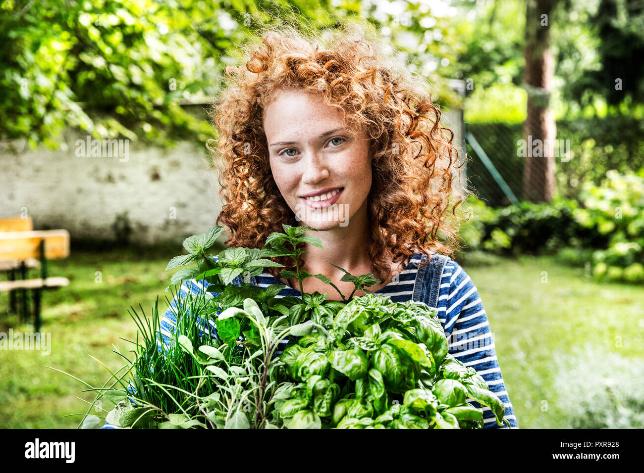 Porträt der jungen Frau mit frischen Kräutern im Garten Stockfoto