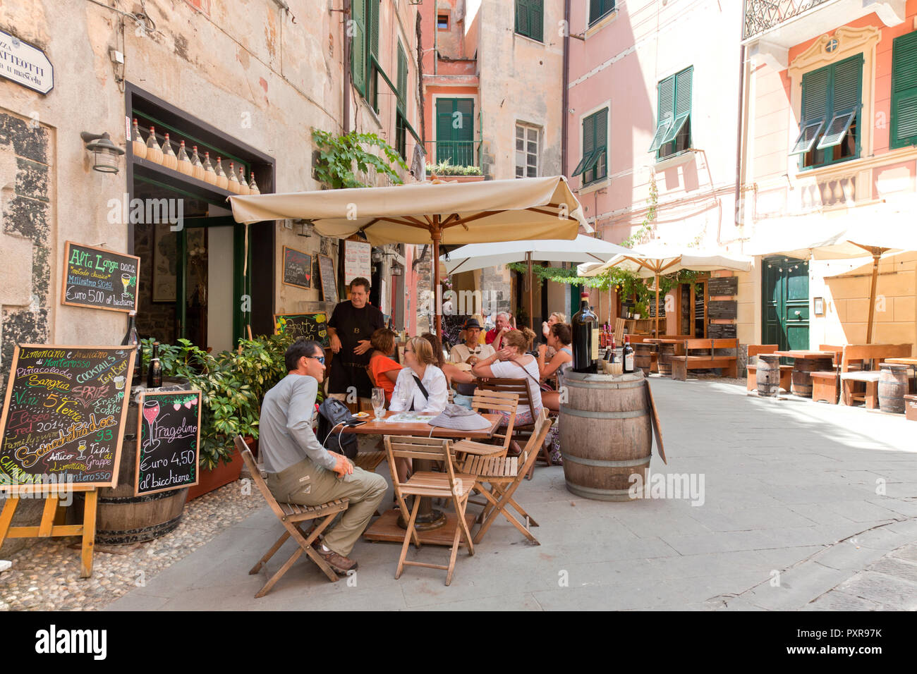 Menschen entspannen an einem bürgersteig Trattoria in Monterosso al Mare, eine Gemeinde in der Provinz von La Spezia, Teil der Region Ligurien. Es ist auf Stockfoto