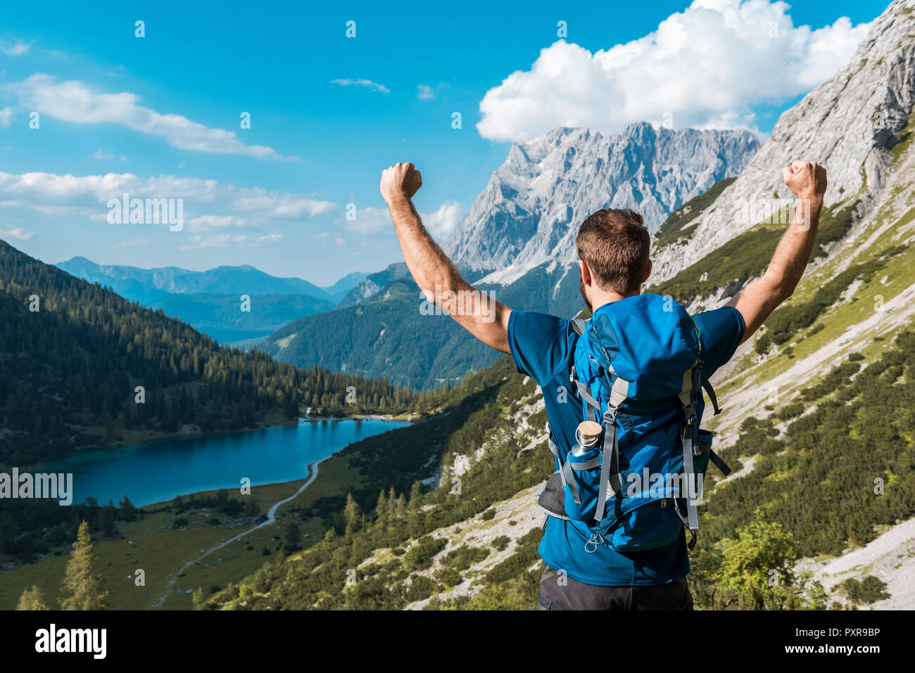 Österreich, Tirol, Wanderer mit Rucksack, Anheben der Arme, mit Blick auf den See Seebensee Stockfoto
