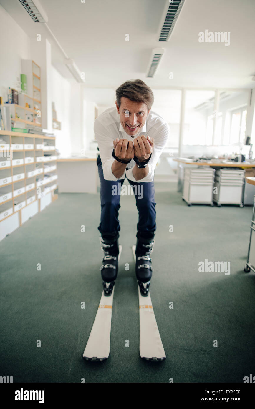 Geschäftsmann Skifahren im Büro Stockfoto