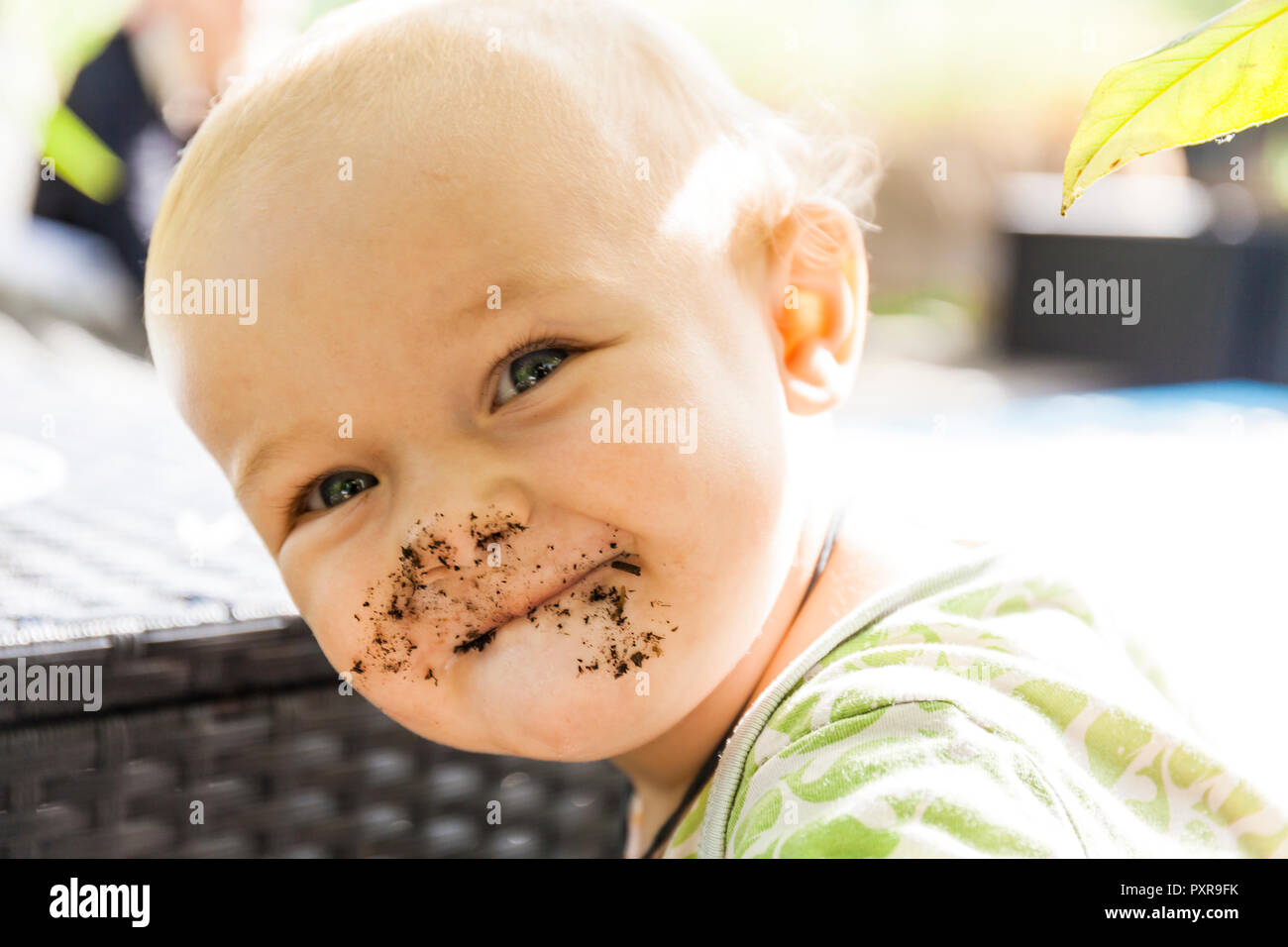 Portrait of smiling baby boy mit Verschmiertem Gesicht im Freien Stockfoto