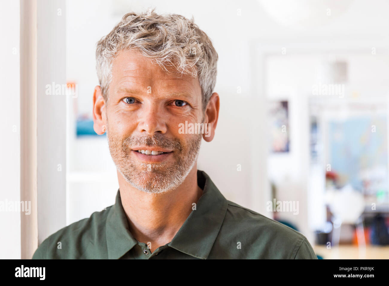 Portrait von lächelnden reifer Mann mit grauem Haar und Stroh zu Hause Stockfoto
