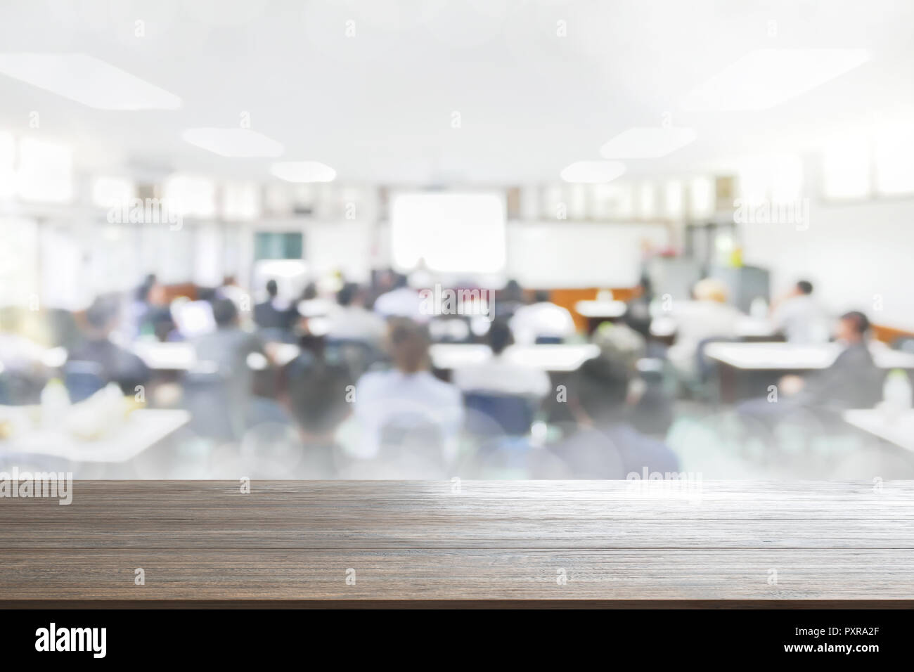 Holz Tisch Hintergrund verschwommen Menschen im Seminarraum Bildung Vortrag oder meetting Konzept, abstrakte blur Menschen Hintergrund Stockfoto