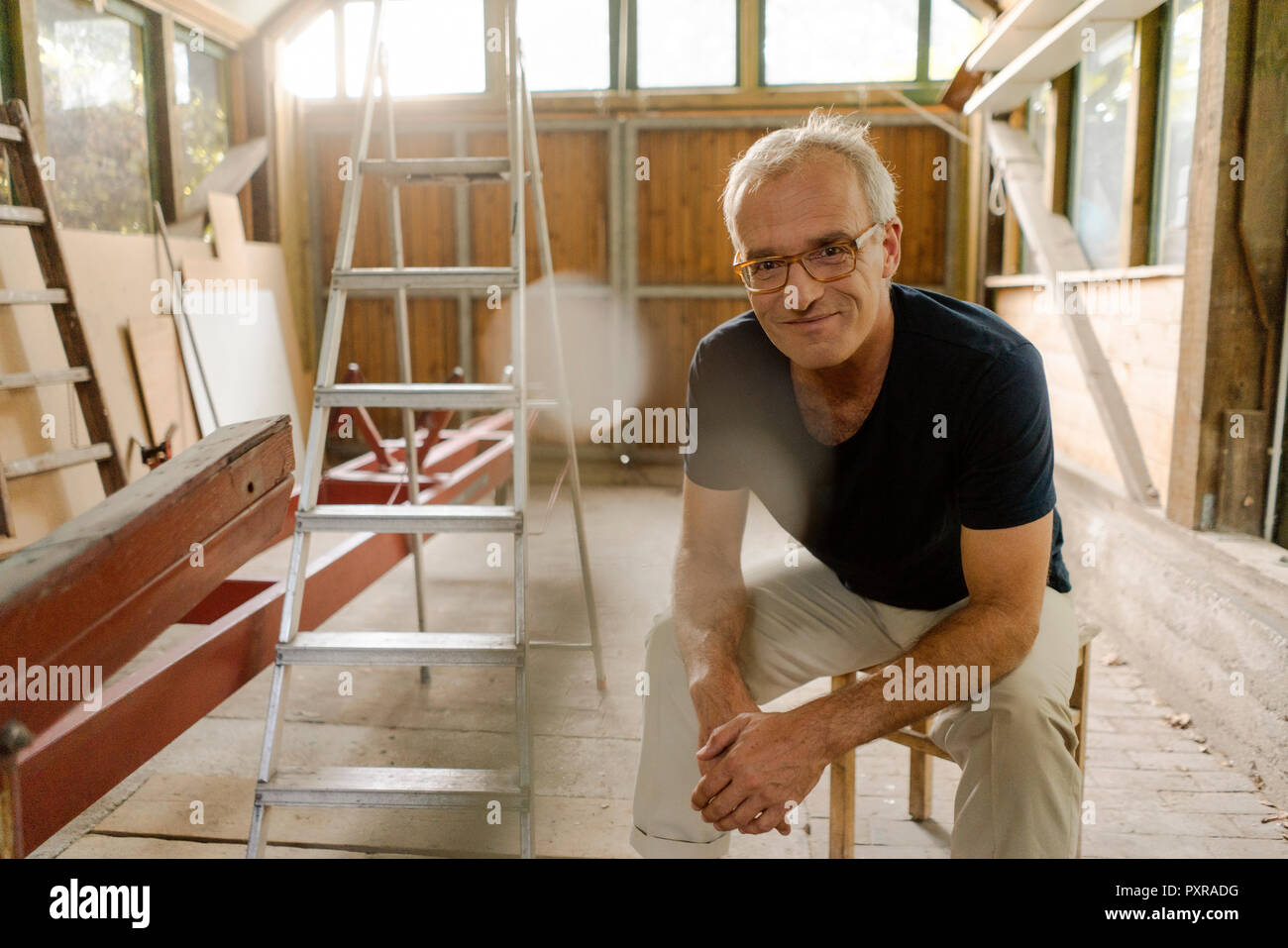 Porträt einer zuversichtlich reifer Mann saß in seinem Workshop Stockfoto