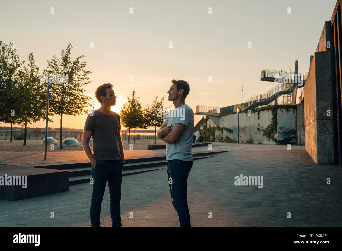 Zwei Freunde treffen bei Sonnenuntergang, am Abend reden Stockfoto