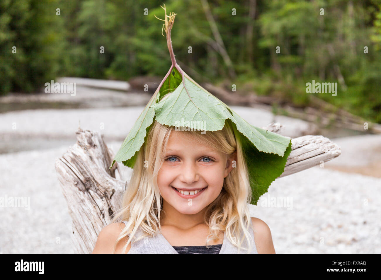 Portrait von glücklichen Mädchen an der Riverside Blätter tragen auf dem Kopf Stockfoto