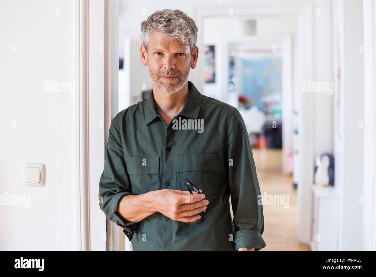 Portrait von reifer Mann mit grauem Haar und Stroh zu Hause Stockfoto