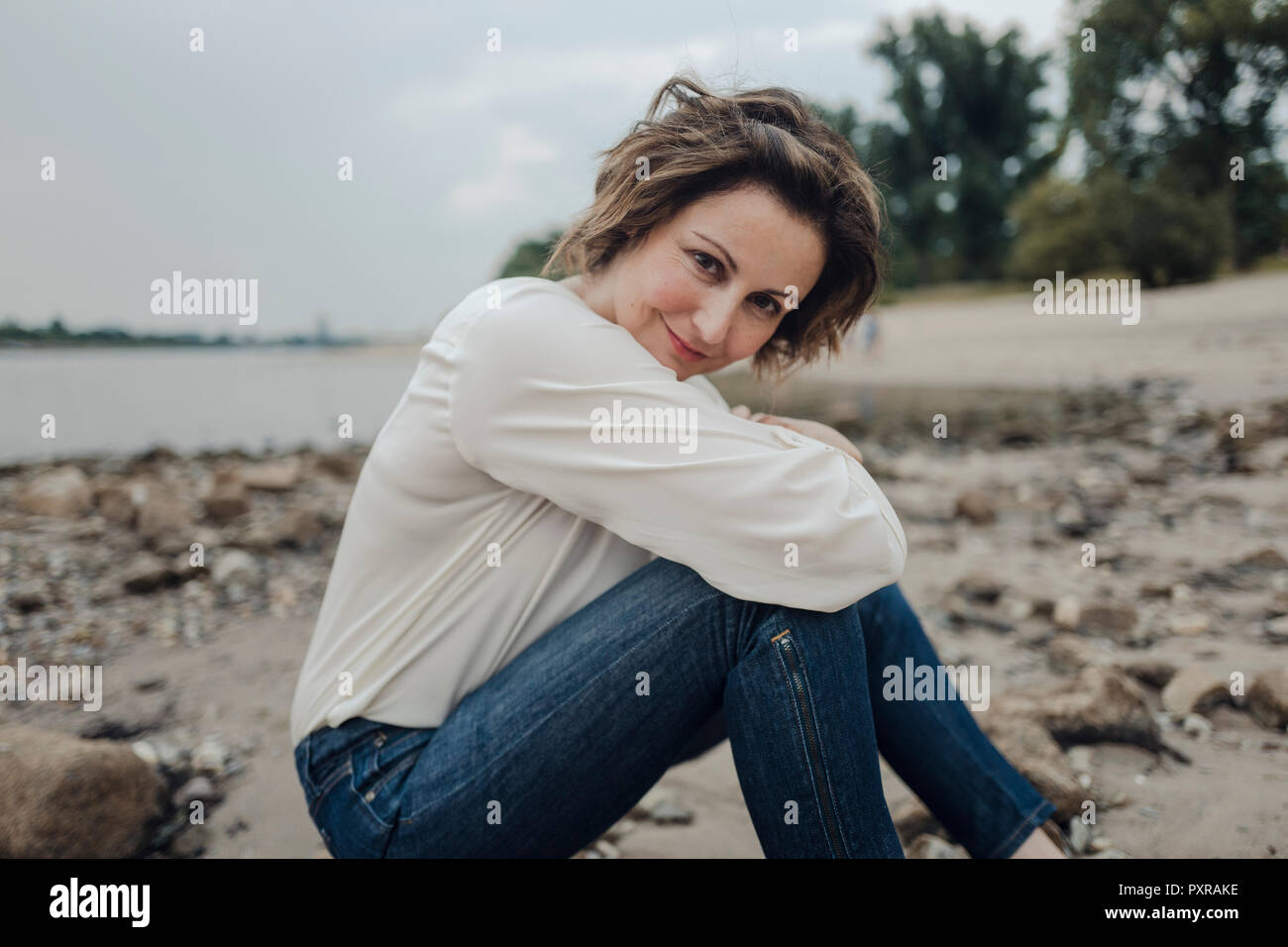 Frau entspannen am Fluss, an der Kamera auf der Suche Stockfoto