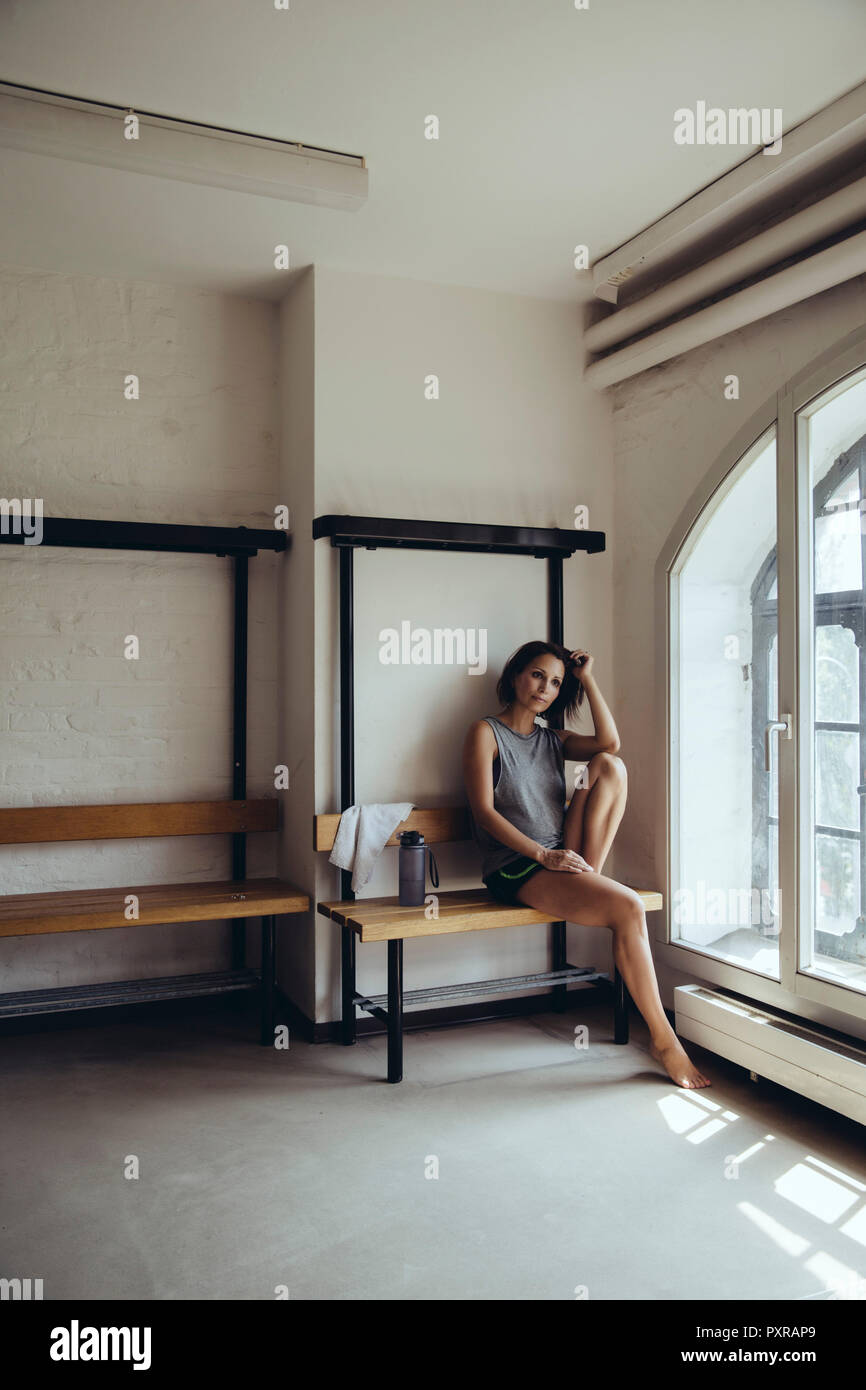 Sportliche Frau in der Umkleide sitzen Stockfoto