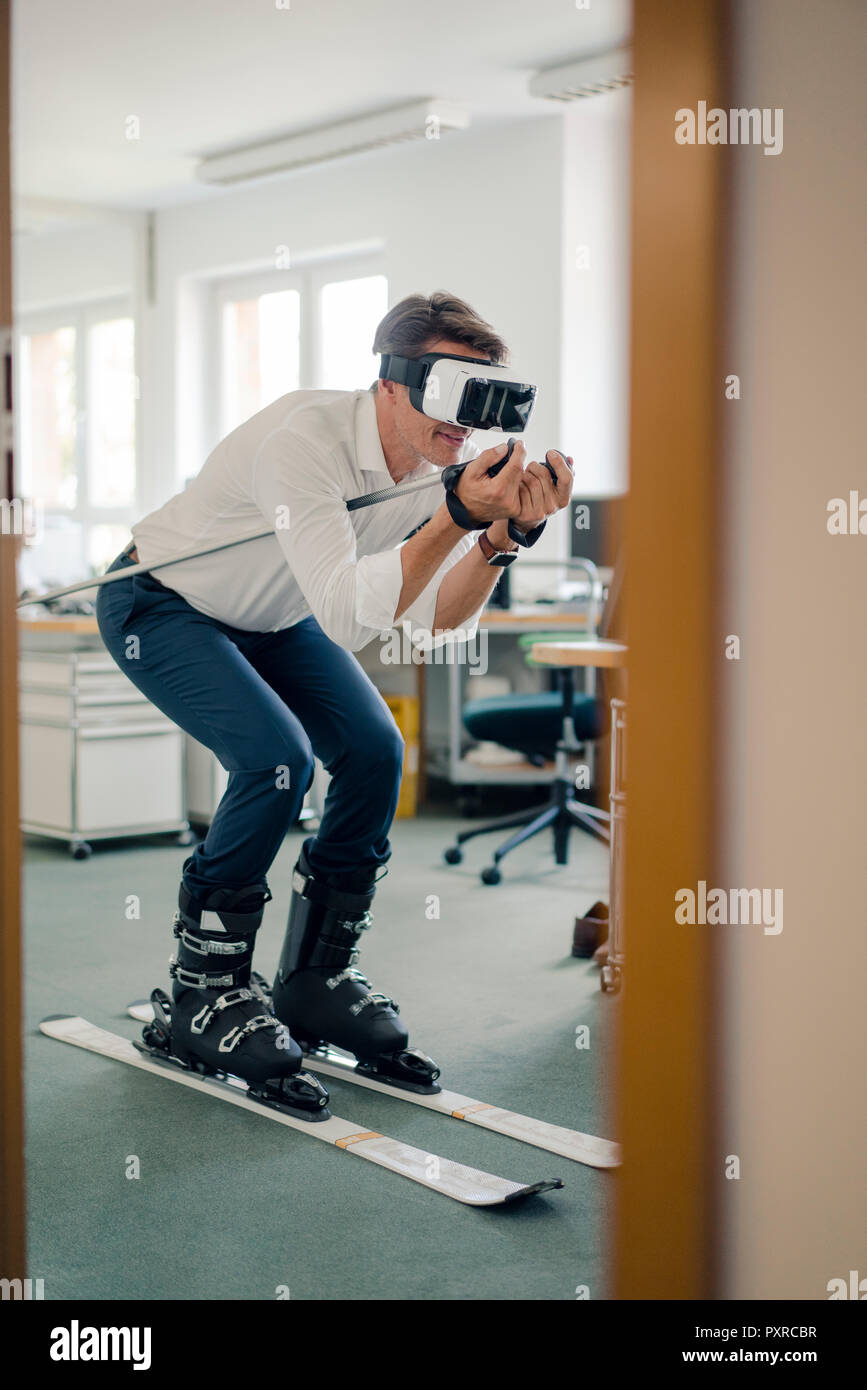 Geschäftsmann Skifahren im Büro, mit VR-Brille Stockfoto