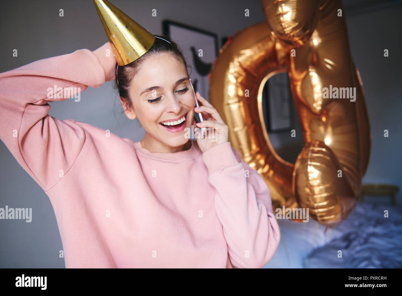 Frau mit über Handy party Hut Stockfoto