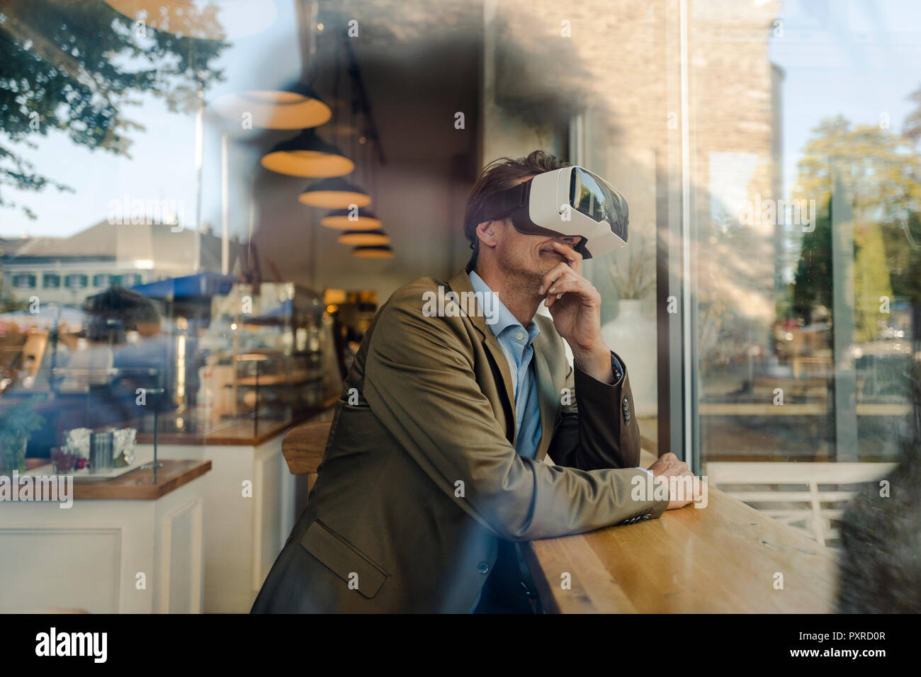 Reifen Geschäftsmann im Café sitzen, schauen durch VR-Brille Stockfoto