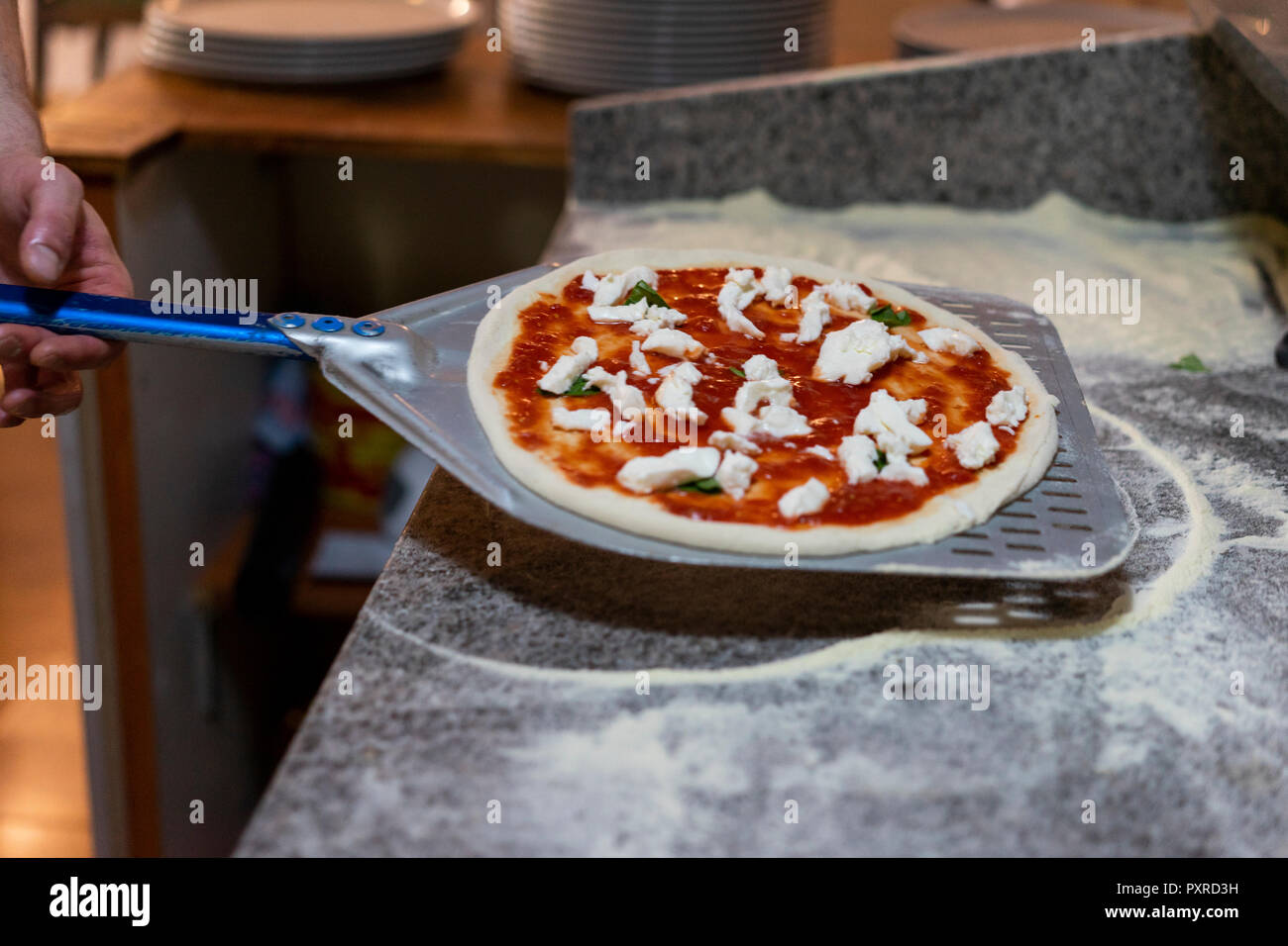 In der Nähe der Pizza Bäcker mit Raw pizza pizza Peel Stockfoto