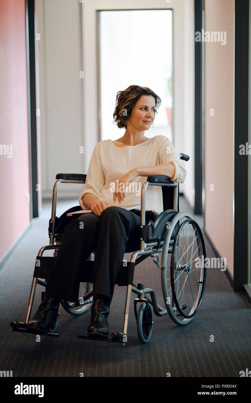 Deaktiviert business Frau sitzt im Rollstuhl, mit Laptop auf den Knien Stockfoto