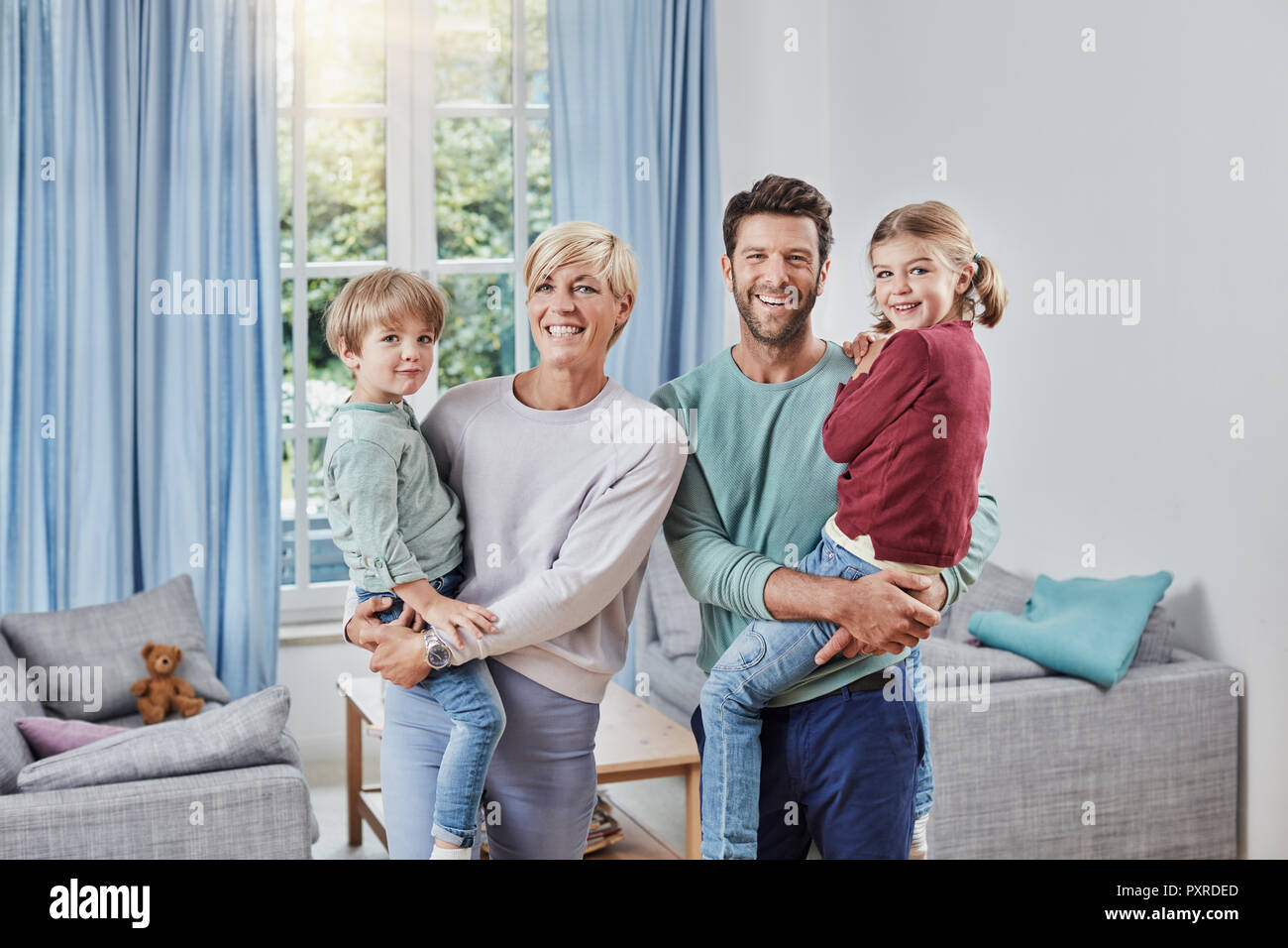 Portrait der glücklichen Familie mit zwei Kindern zu Hause Stockfoto