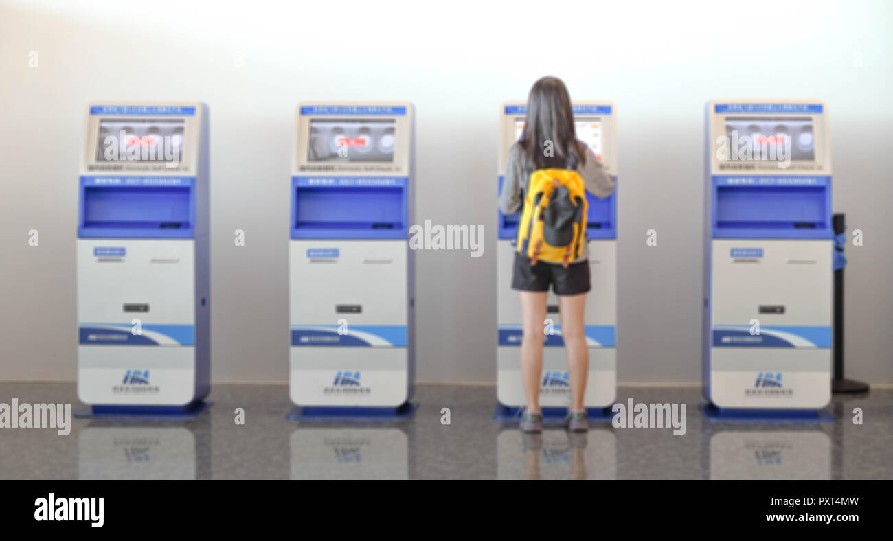 China Wuhan Tianhe - September 10, 2018: Die junge Frau mit dem Check-in-Automaten am Flughafen erhalten der Bordkarte. Es ist blur Bild. Stockfoto