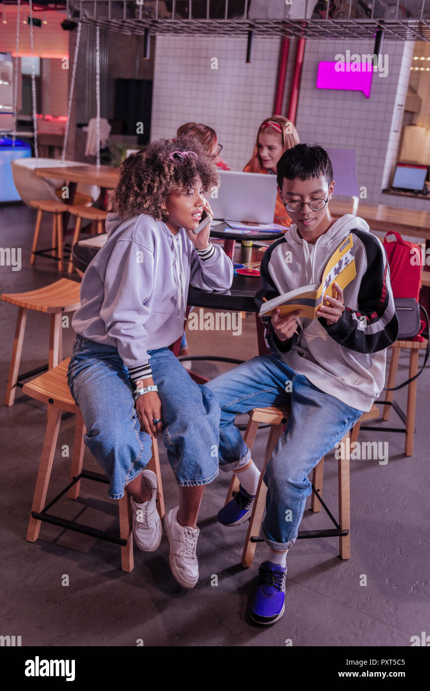 Clever international Teenager seine Klassenkameradin helfen bei der Aufgabe Stockfoto