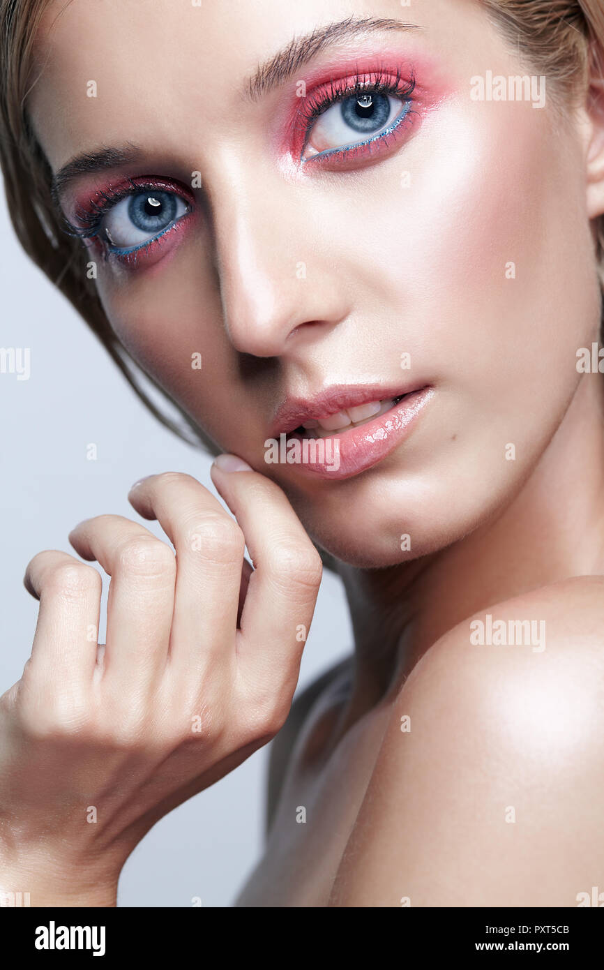 Portrait von schönen Mädchen. Junge Frau mit langen blonden Haaren. Frau posiert auf grauem Hintergrund. Stockfoto