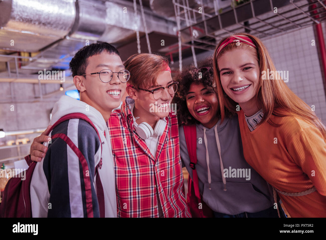 Positiv erfreut, internationale Freunde gerade an der Kamera auf der Suche Stockfoto