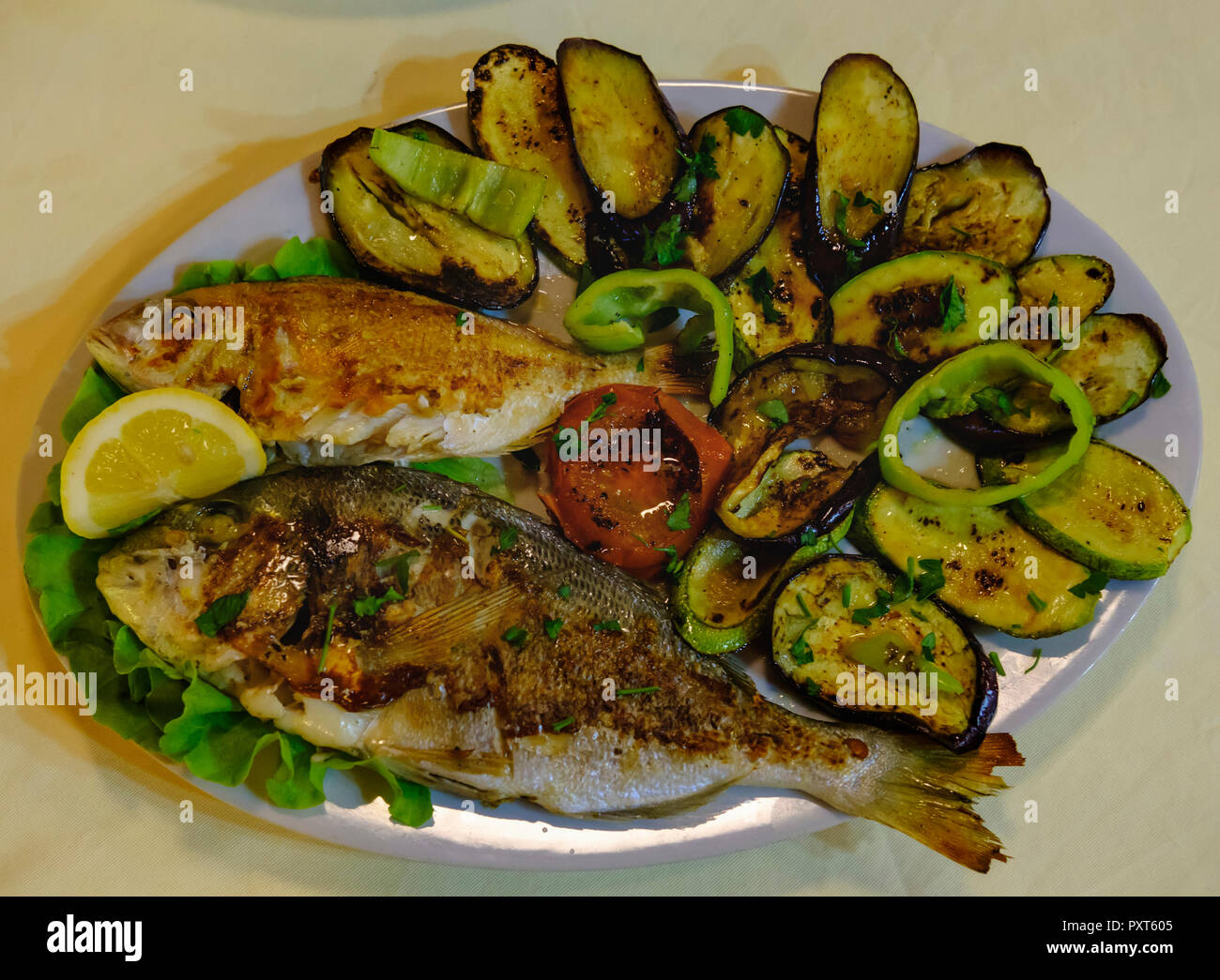 Gegrillten Fisch und gegrilltes Gemüse serviert auf Platte, qark Vlora, Albanien Stockfoto